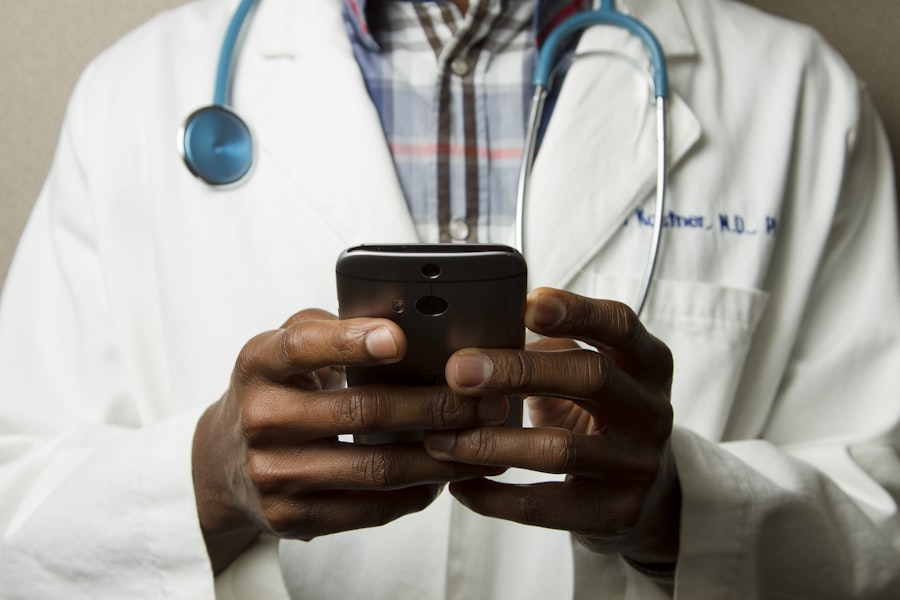 Doctor in white coat holding smartphone with stethoscope visible