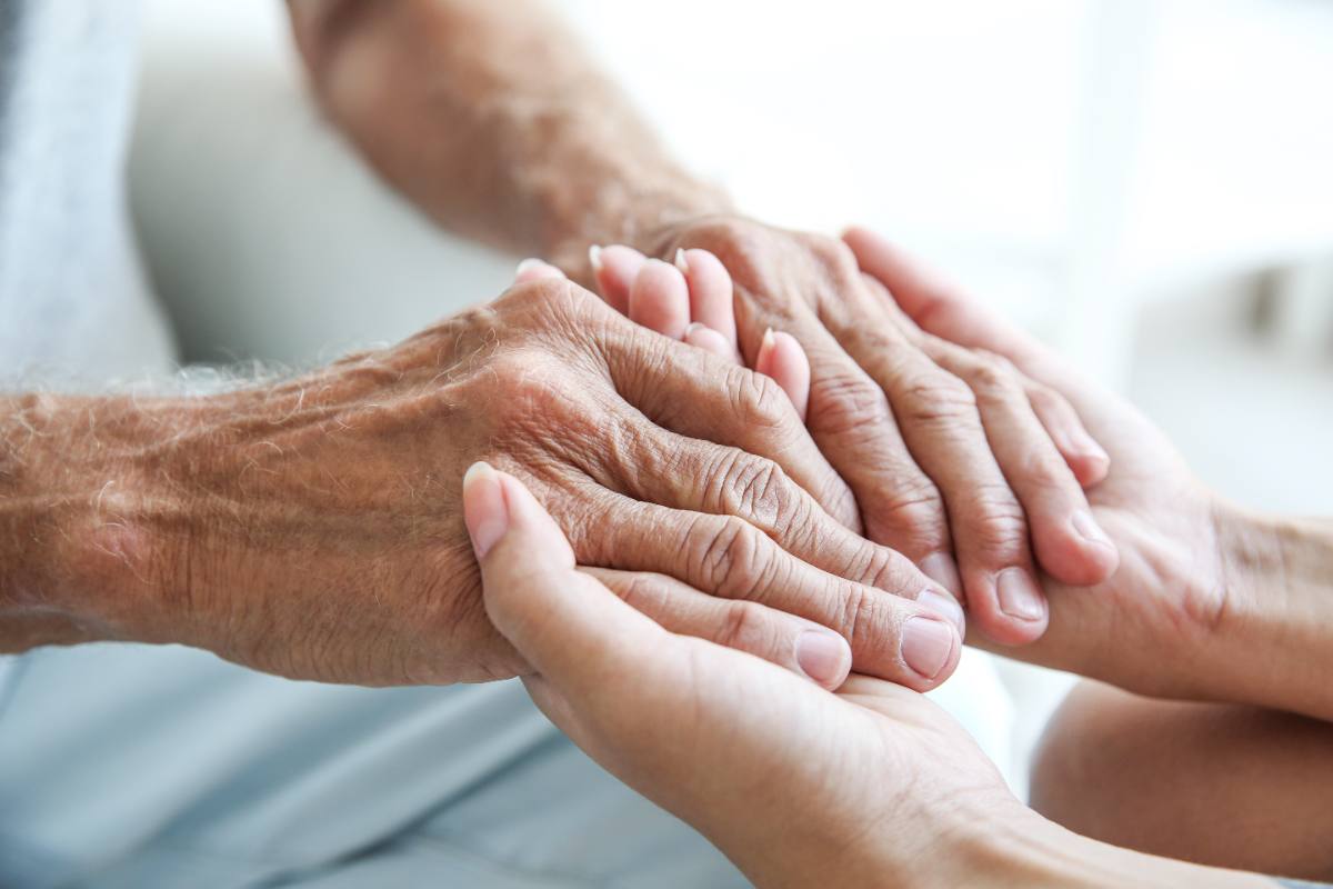Hands of different generations stacked together in a gesture of unity and support